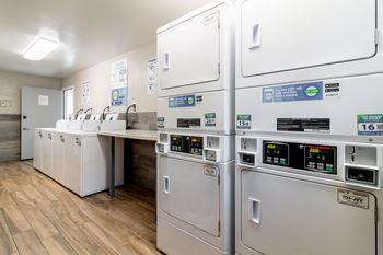 a kitchen with a row of refrigerators and a counter with sinks at Alturas Paso Robles Apartment Homes, Paso Robles, 93446